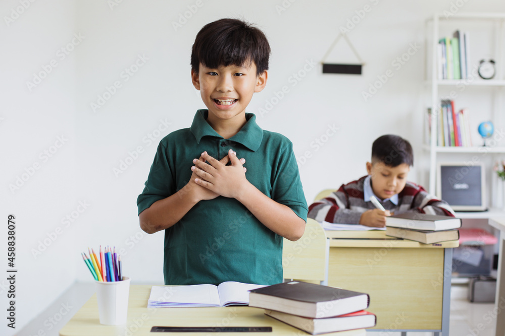 An Asian student stands up and introduces himself in class An Asian student stands up and introduces himself in class