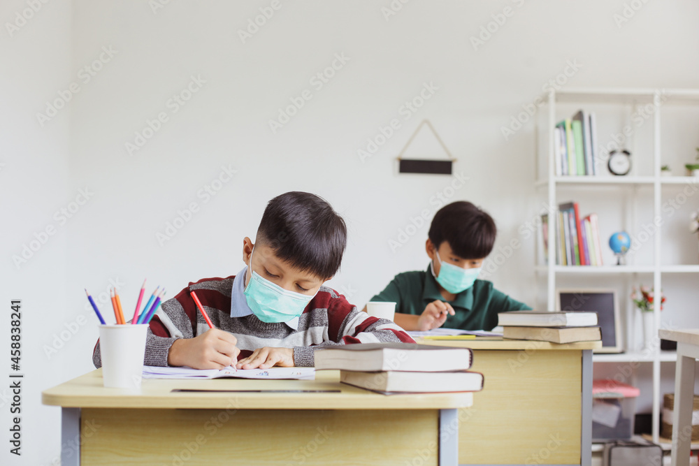 Students in medical mask are studying and doing assignments in class Students in medical mask are studying and doing assignments in class