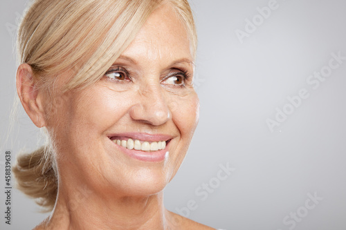 Portrait of beautiful blond senior woman posing and looking at the camera. Beauty photography