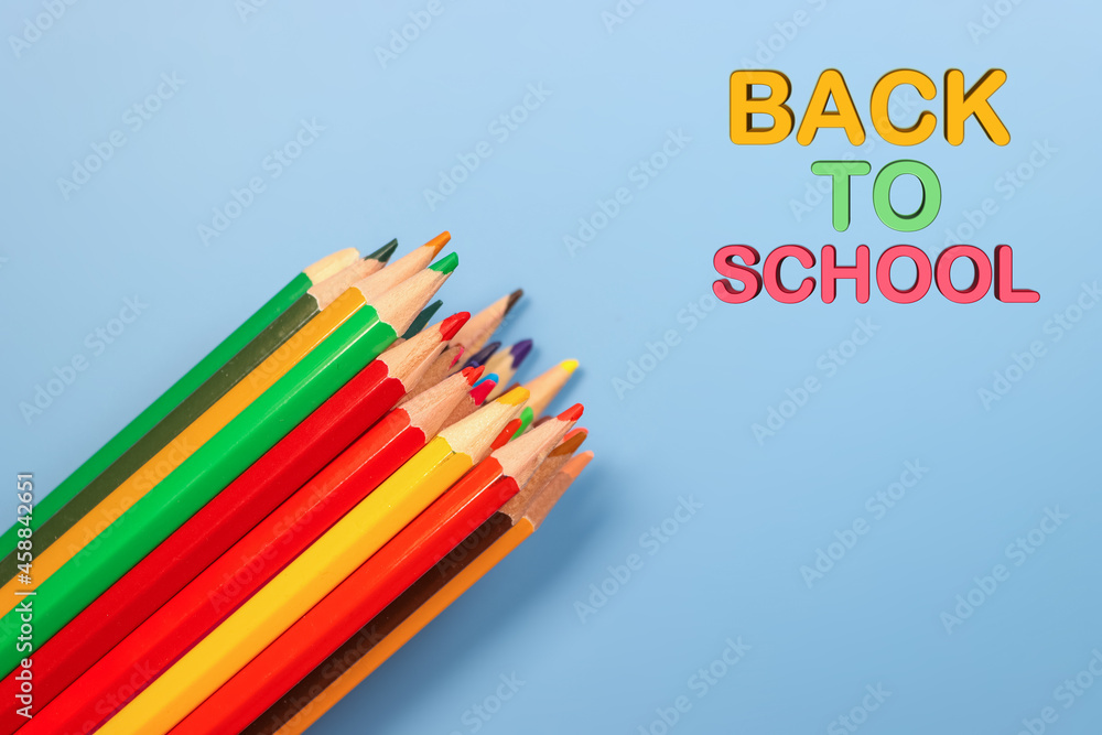 Fototapeta premium Colorful pencils on blue background with back to school text