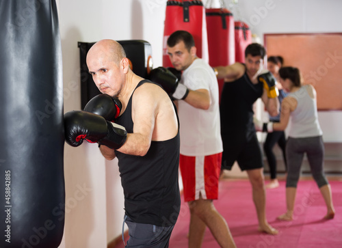 people beating boxing bag training in boxing gloves © JackF