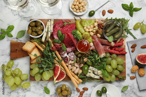 Set of different delicious appetizers served on white marble table, flat lay