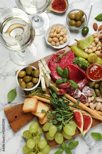 Set of different delicious appetizers served on white marble table, flat lay