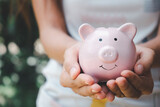 Woman hand holding piggy bank, saving, charity,  fundrasing community care, superannuation, financial crisis concept