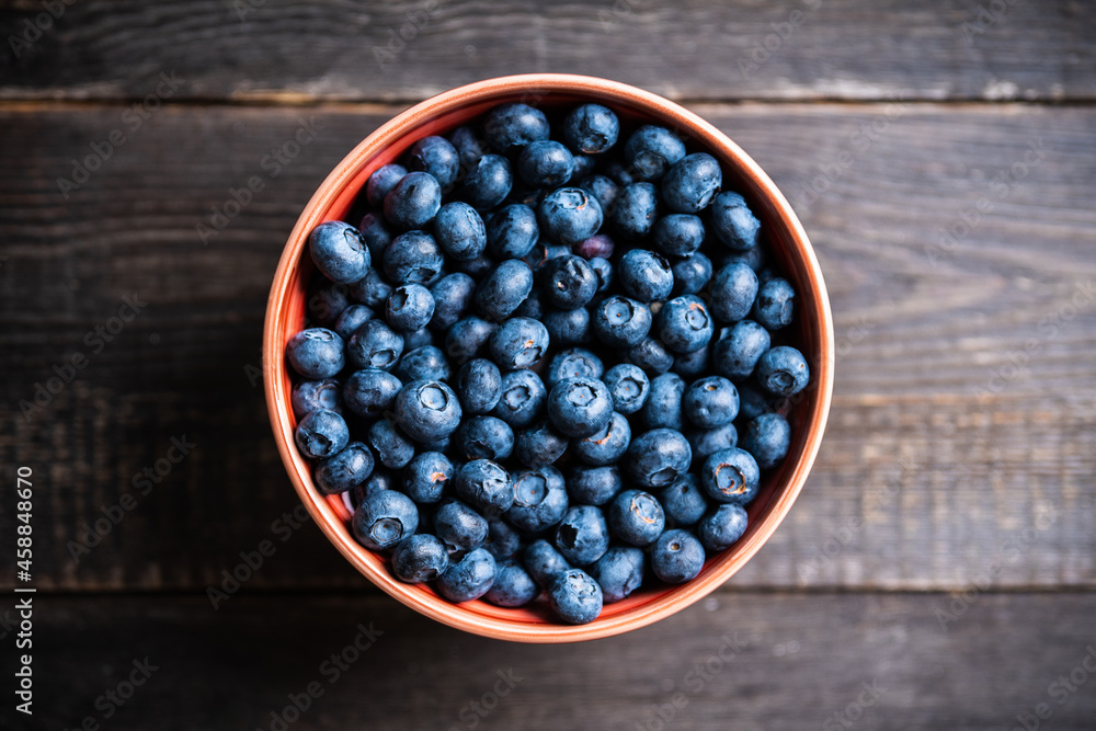 Blueberries in ceramic bowl on rustic wooden background. Selective focus. Shallow depth of field. Blueberries in ceramic bowl on rustic wooden background. Selective focus. Shallow depth of field.