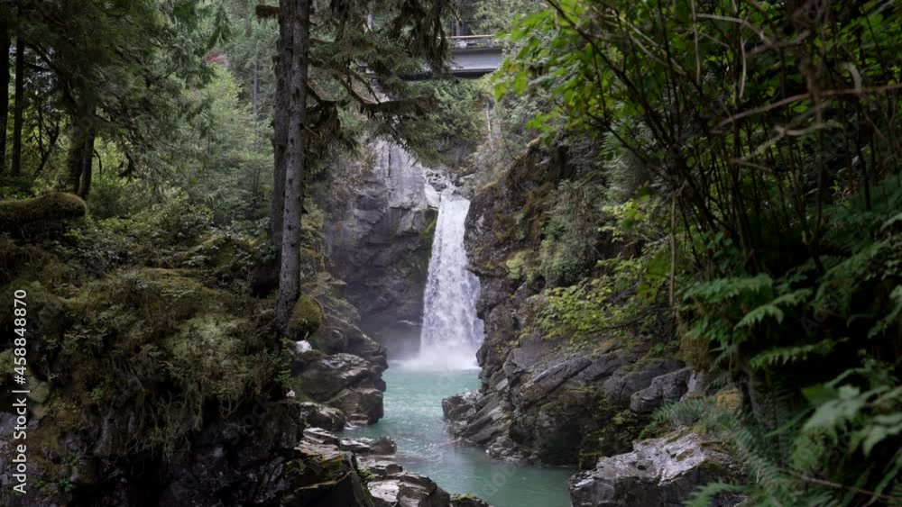 Water From Mamquam Falls Flowing Into Rocky And Narrow Stream In Squamish, BC, Canada. - wide shot Water From Mamquam Falls Flowing Into Rocky And Narrow Stream In Squamish, BC, Canada. - wide shot