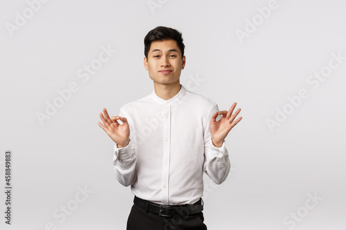 Neat, that was amazing. Impressed and proud sassy, arrogant asian businessman bragging personal achievement, showing alright, all is good gesture, smirk pleased, white background photo