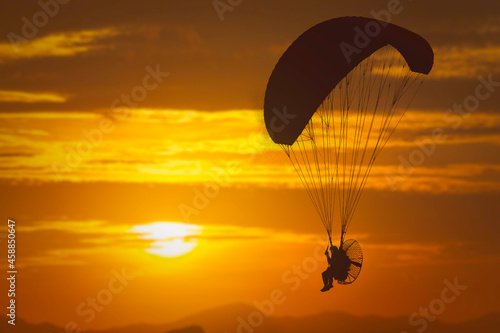 silhouette of paramotor sunset background