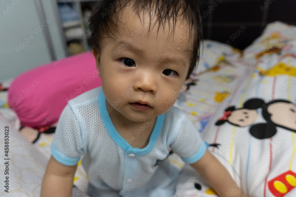 Portrait Adorable and happy Chinese baby boy child relaxing in bed Portrait Adorable and happy Chinese baby boy child relaxing in bed