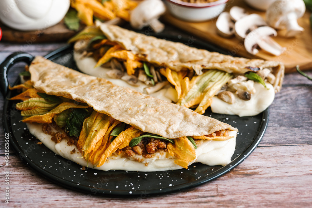 Chicharron and mushroom quesadillas with squash blossom, typical dish from Mexico Chicharron and mushroom quesadillas with squash blossom, typical dish from Mexico