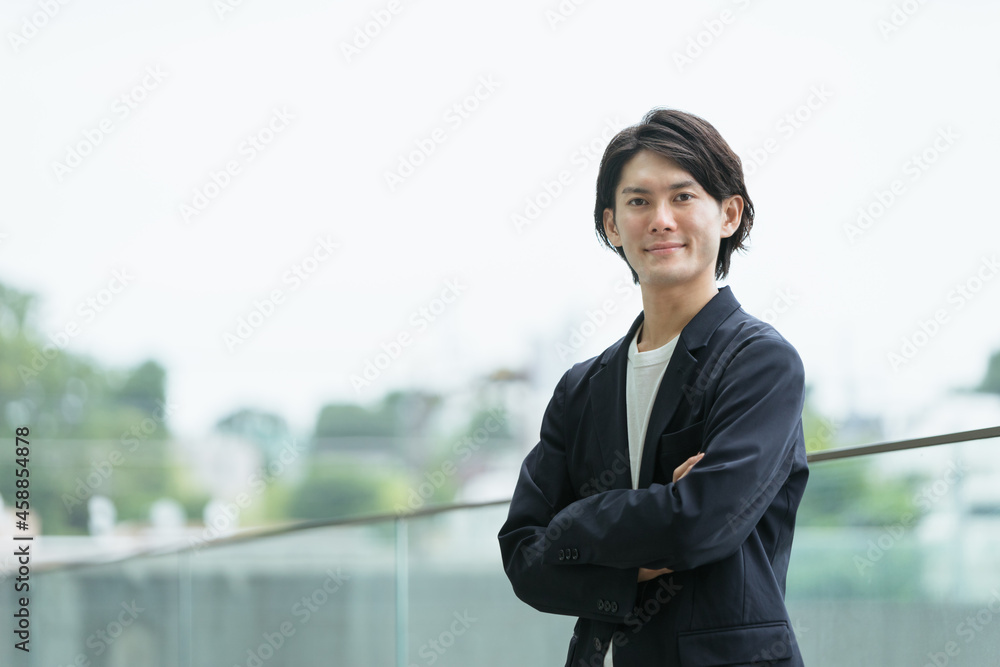 腕組みをする若い男性・若手経営者