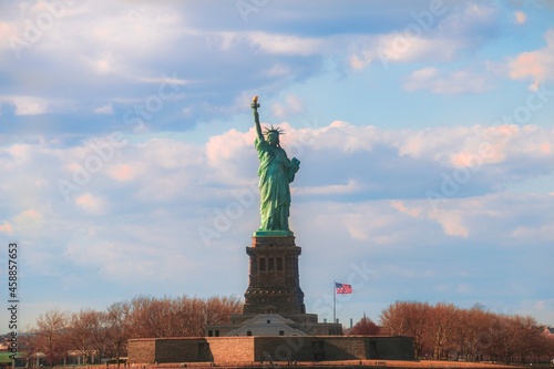 The Statue of Liberty with the American flag along the Hudson River in New York.
