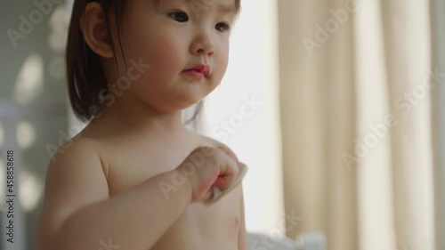 topless lovely baby asian girl playing at home clean her face