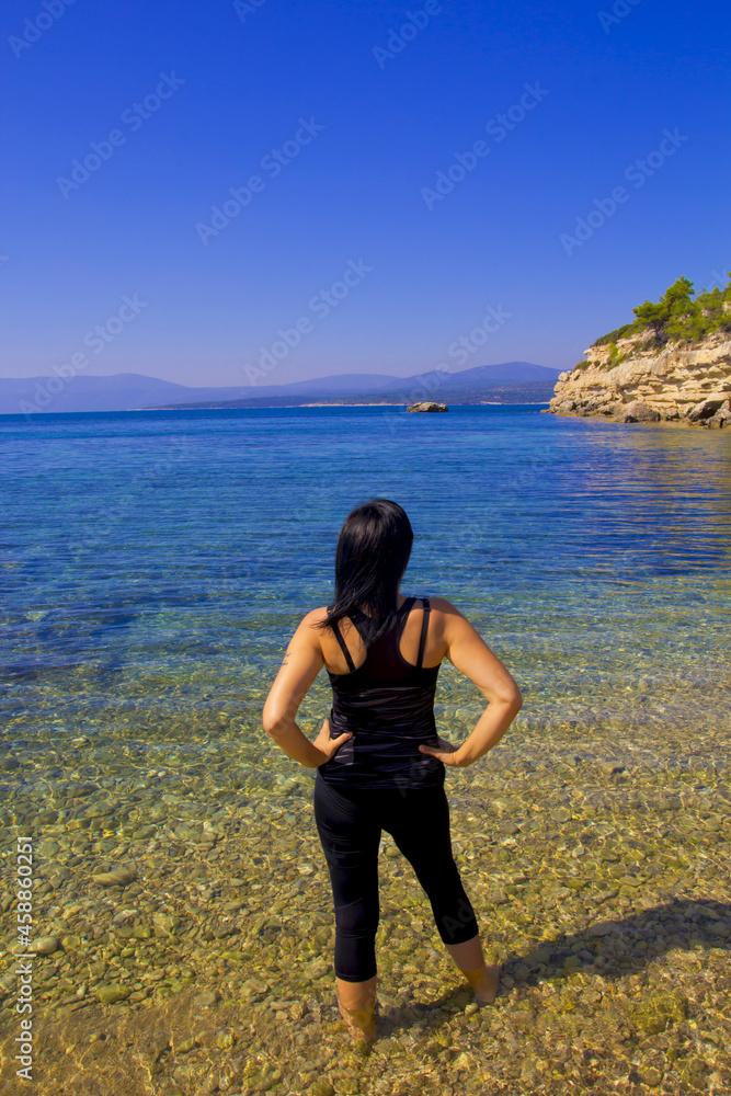 young woman standing on the beach in summer