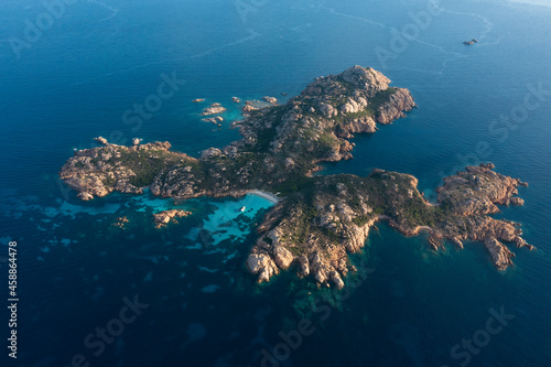 View from above, stunning aerial view of Mortorio island with a beautiful white sand beach and a boat floating on a turquoise water. Sardinia, Italy.