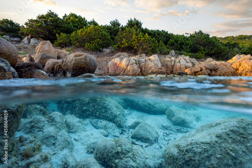 Split shot, over under photo. Half underwater with turquoise water and a rocky coast on the water surface. Prince Beach (Spiaggia del Principe) Sardinia, Italy.