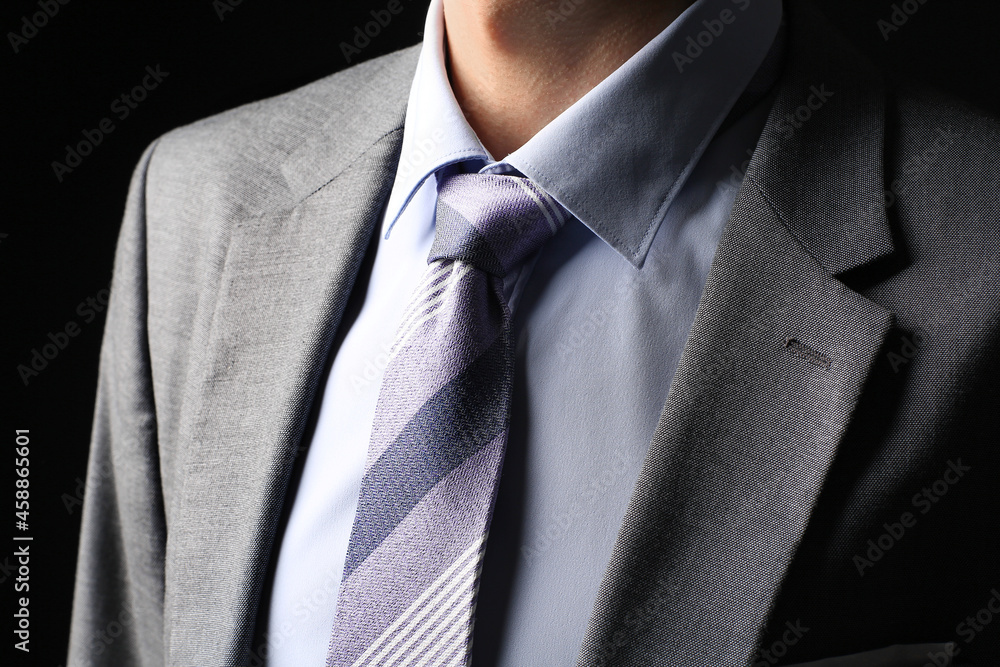 Young man in stylish suit on dark background, closeup Young man in stylish suit on dark background, closeup