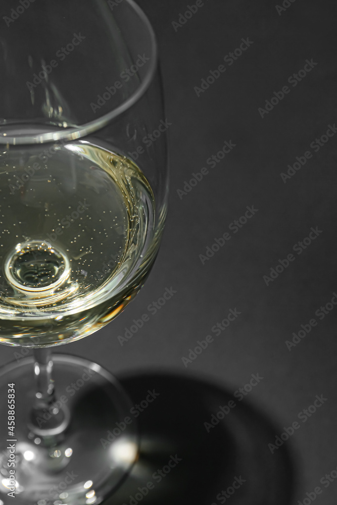 Glass of white wine on dark background, closeup Glass of white wine on dark background, closeup