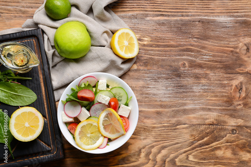 Plate with healthy salad on wooden background