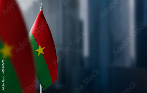 Small flags of Burkina Faso on a blurry background of the city