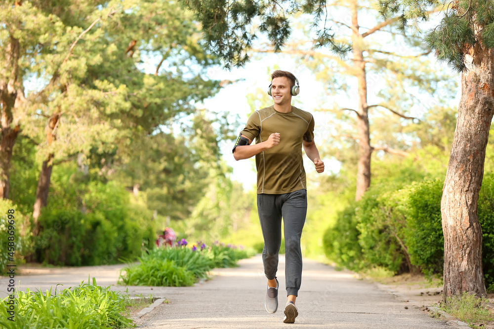 Sporty young man with headphones running in park