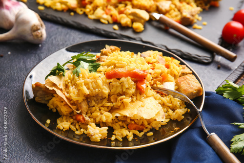 Plate with tasty Shah Pilaf on dark background