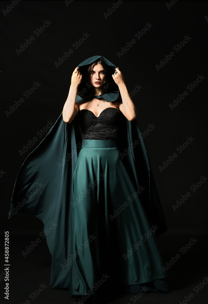 Beautiful woman dressed as witch for Halloween party on dark background