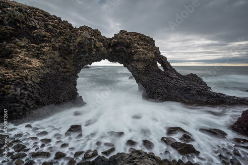 Iceland, Arnarstapi. Rock arch with the ocean beneath at, Snaefellsjokull, Snaefellsnes Peninsula photo
