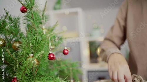 A young man decorates a Christmas tree vintage balls. Hands close-up. Merry Christmas and Happy Holidays. .The morning before Xmas. Banner with copy space.