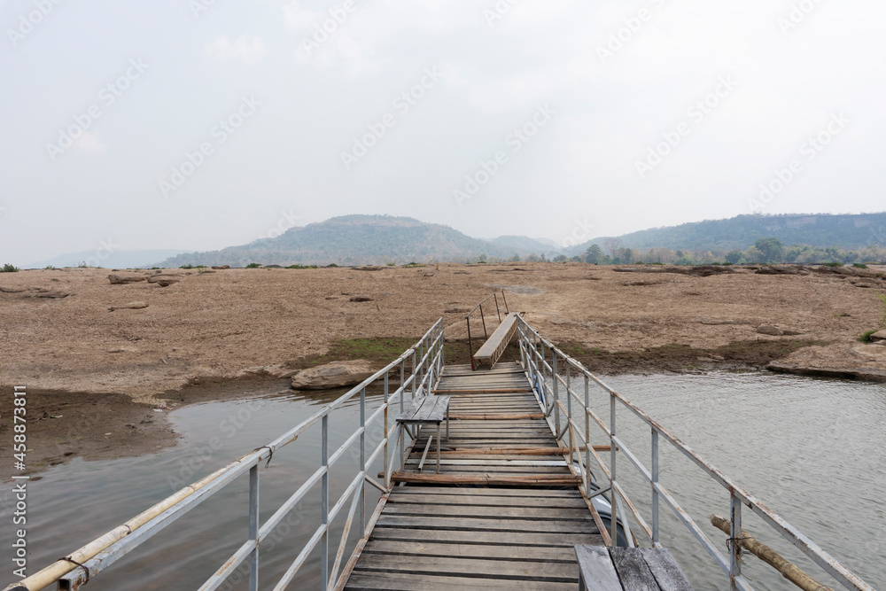 Landscape of the bridge across the brown dried land field after the long drought and rainless season