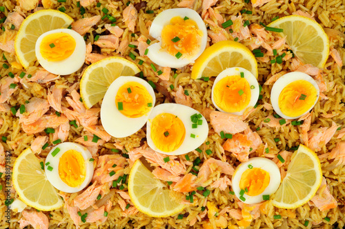 Salmon kedgeree meal background with flaked salmon and spicy curry flavour rice and boiled eggs