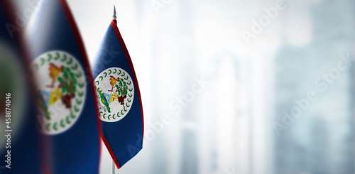 Small flags of Belize on a blurry background of the city