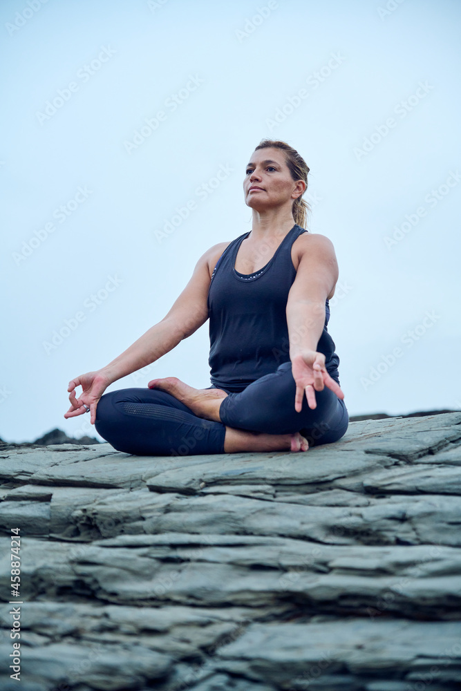 woman practicing yoga and fitness on some rocks