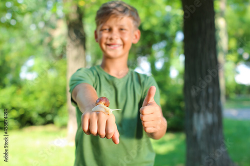 Happy little boy with snail...