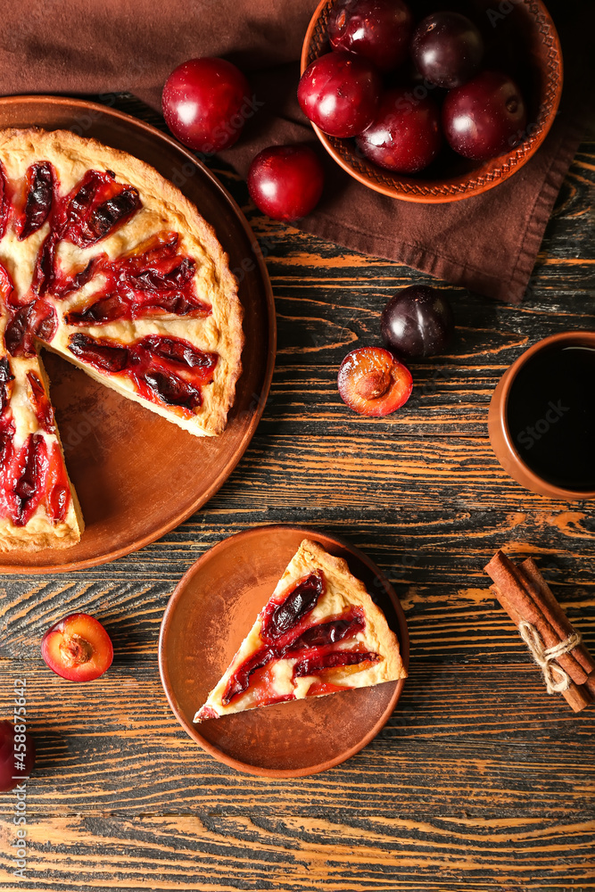 Composition with tasty plum pie and cup of tea on wooden background