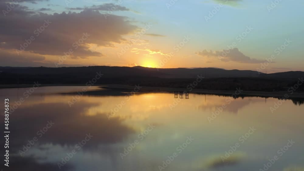 Orange Golden Sunset Reveal behind mountain, sky reflection on water Orange Golden Sunset Reveal behind mountain, sky reflection on water
