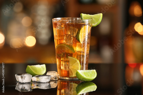 Billede på lærred Glass of refreshing Long Island iced tea with limes on table in bar
