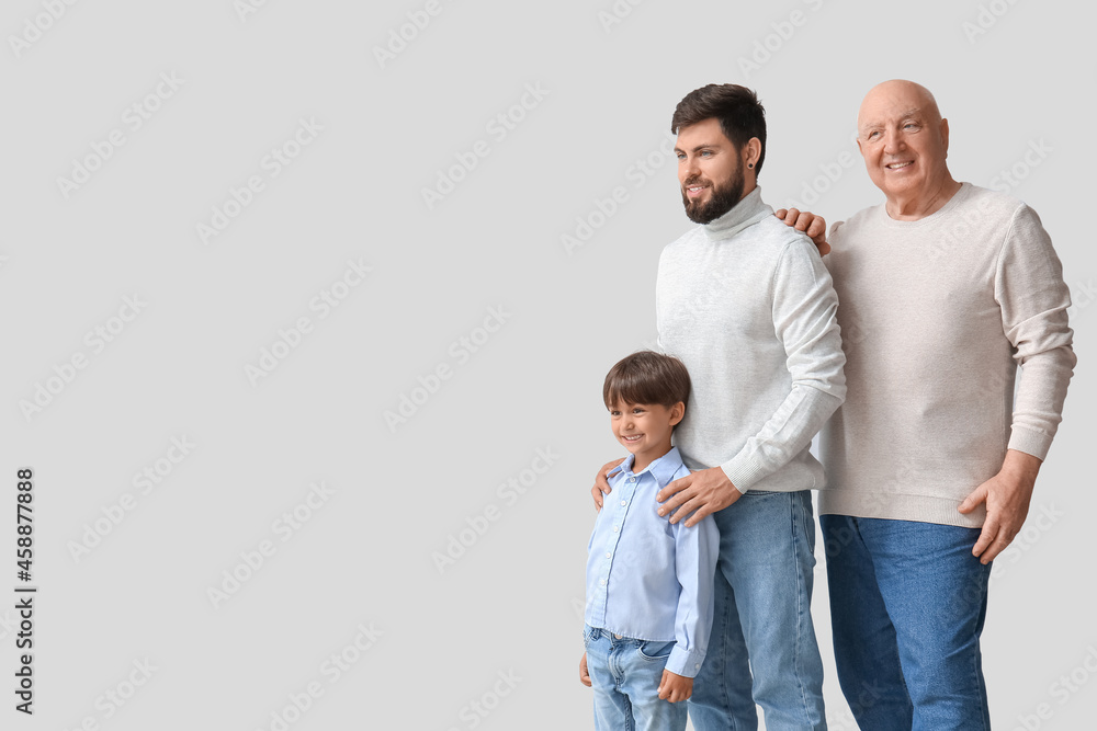 Happy man, his little son and father on light background