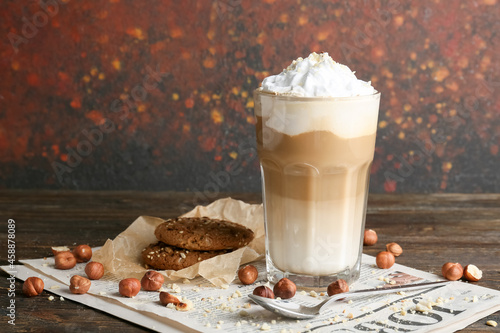 Obraz na plátně Glass of tasty latte with nuts and cookies on table