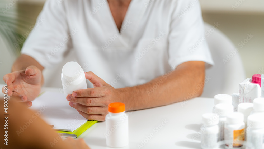 Quantum Medicine. Doctor Holding a Supplement Bottle, recommending supplements to a client. Quantum Medicine. Doctor Holding a Supplement Bottle, recommending supplements to a client.