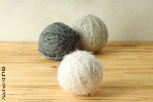 Balls of yarn on wooden table, selective focus