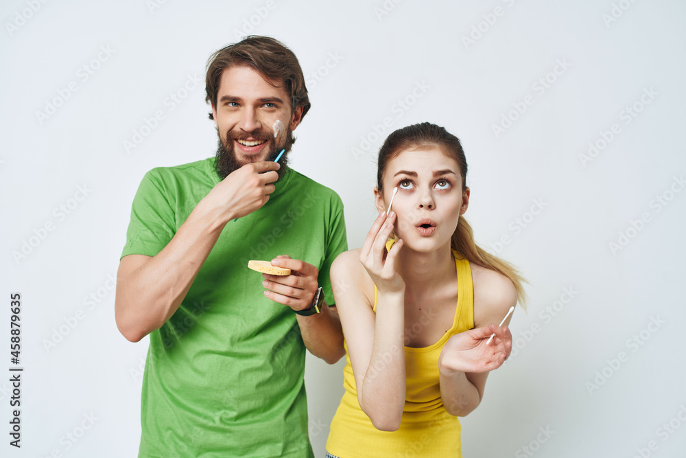 young couple in multicolored t-shirts facial skin care shaving young couple in multicolored t-shirts facial skin care shaving