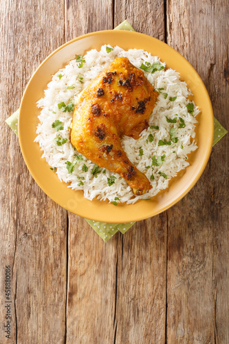 Ayam Percik Coconut Spiced Chicken with rice close up in the plate on the table. Vertical top view from above photo