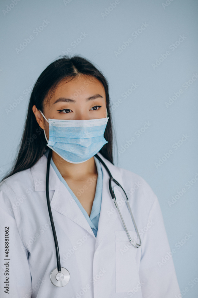 Young woman surgeon on blue background with stethoscope Young woman surgeon on blue background with stethoscope