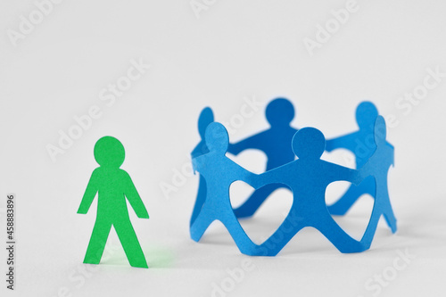 Group of people holding hands in circle and person alone - Concept of social exclusion and isolation photo