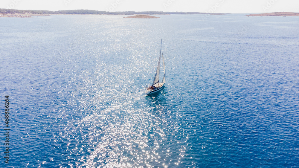 Obraz premium Drone aerial view of a sailing boat on a blue ocean sea waters.