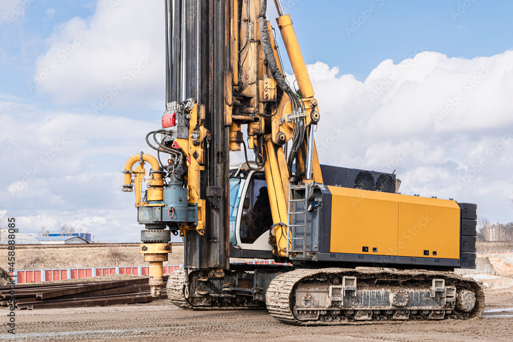 Powerful hydraulic drilling rig on a construction site. Installation of bored piles by drilling. Pile foundations. Drilling in the ground. Powerful hydraulic drilling rig on a construction site. Installation of bored piles by drilling. Pile foundations. Drilling in the ground.