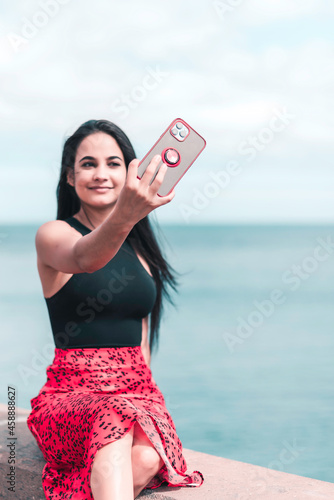 Long black hair woman is making selfie with her mobile phone. Social media using conceptLong black hair woman is making selfie with her mobile phone. Social media using concept photo