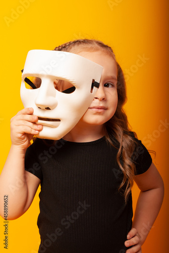 a cute girl of American appearance with a mime mask on her face in half. Theatre actress for theatre day, mime day, with space for text