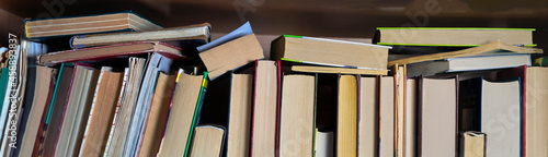 Photography Background with books standing and lying on the shelf. Close-up.